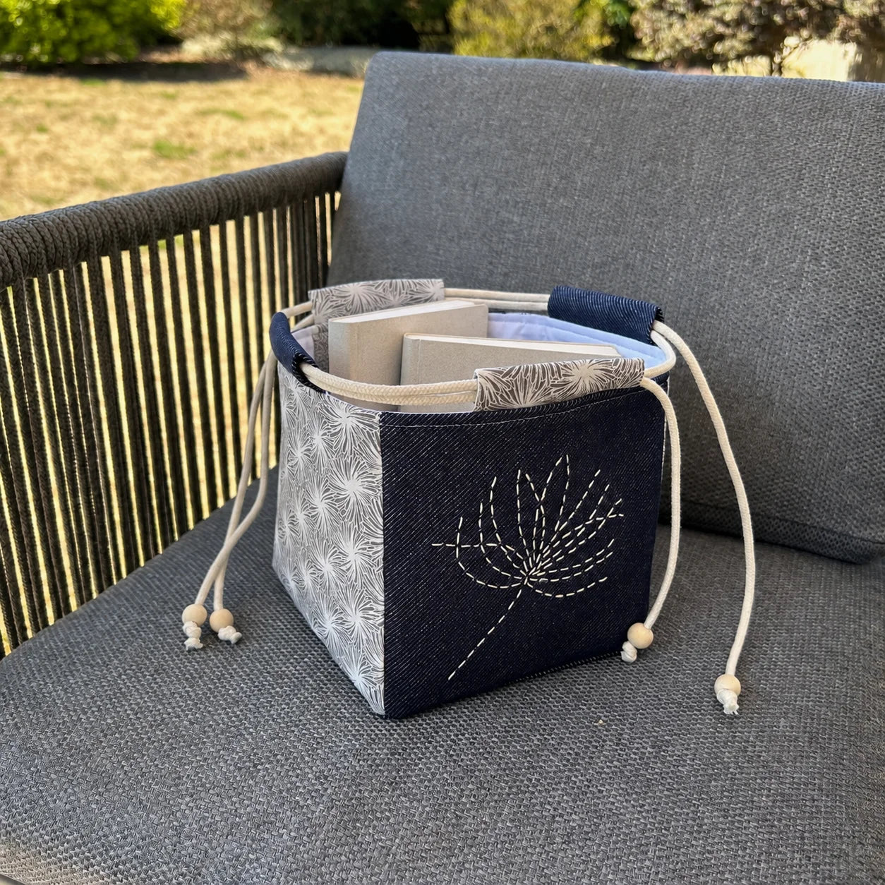 sac japonais brodé posé sur chaise et contenant des livres