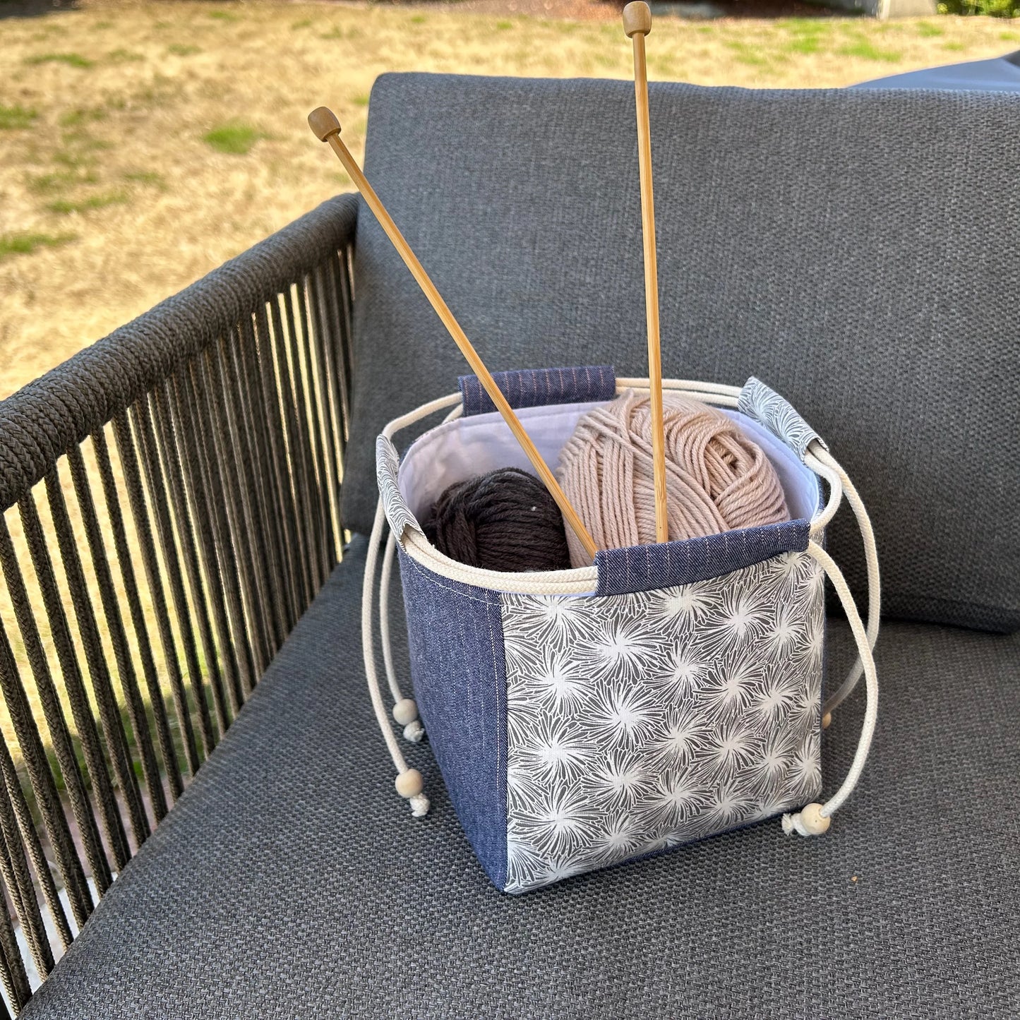 Sac japonais imprimé fleurs posé sur chaise et contenant pelotes et aiguilles