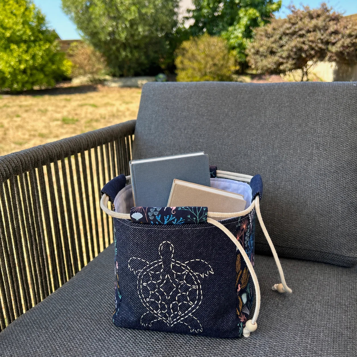 sac japonais brodé posé sur chaise et contenant des livres