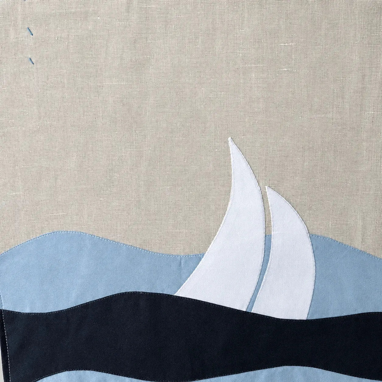 détail appliqué tissu mer et voilier sur tenture murale
