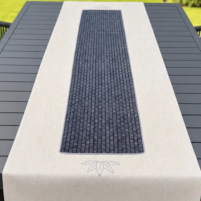 Chemin de table beige avec appliqué au centre imprimé, présenté sur une table de jardin