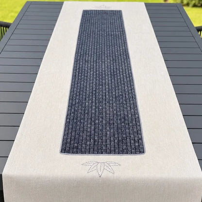 Chemin de table beige avec appliqué au centre imprimé, présenté sur une table de jardin