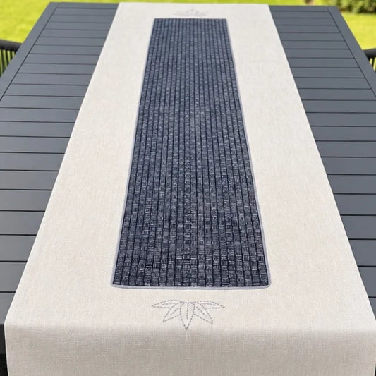 Chemin de table beige avec appliqué au centre imprimé, présenté sur une table de jardin