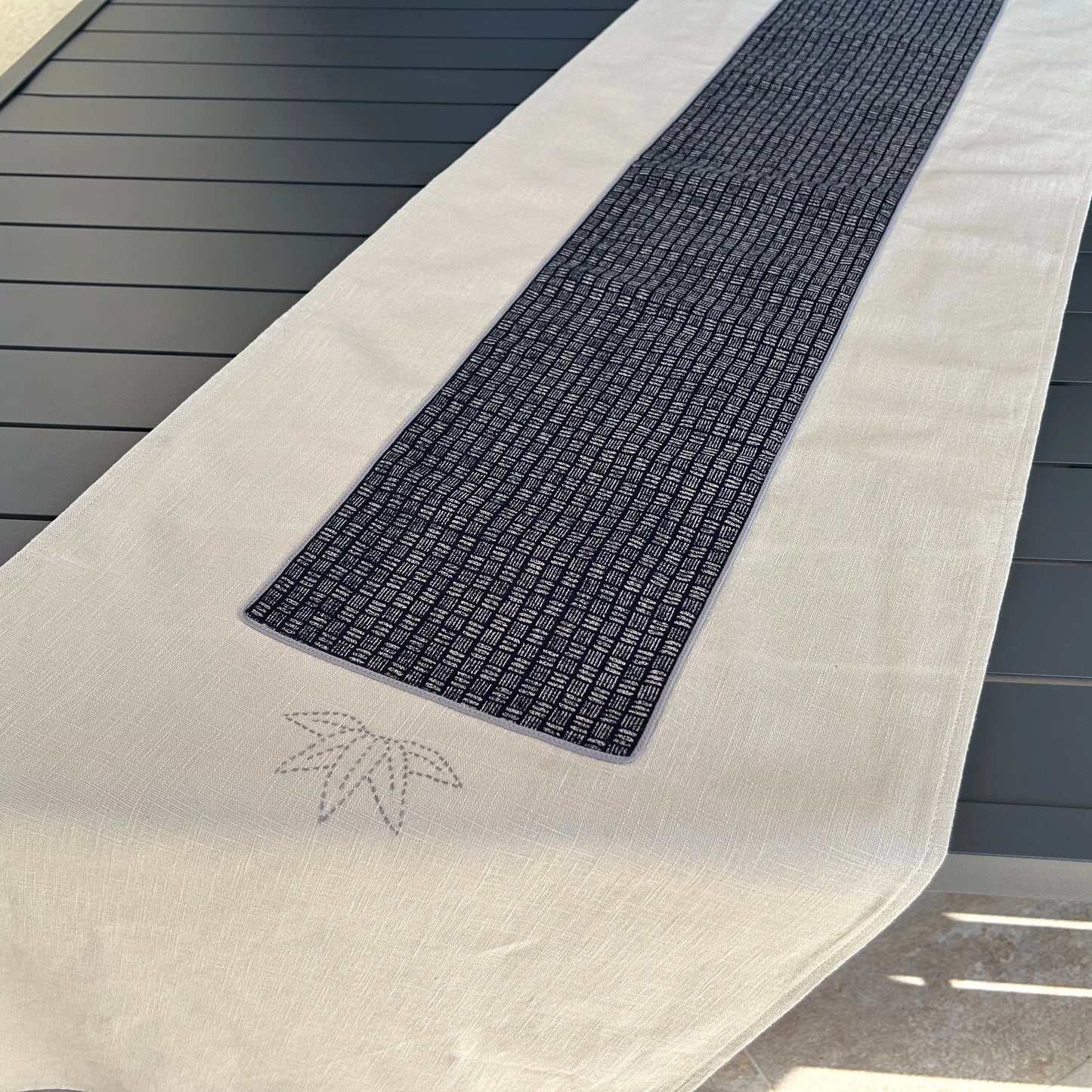 Chemin de table sur table de jardin en biais avec broderie en premier plan