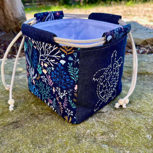 sac japonais brodé tortue posé sur pierre de jardin