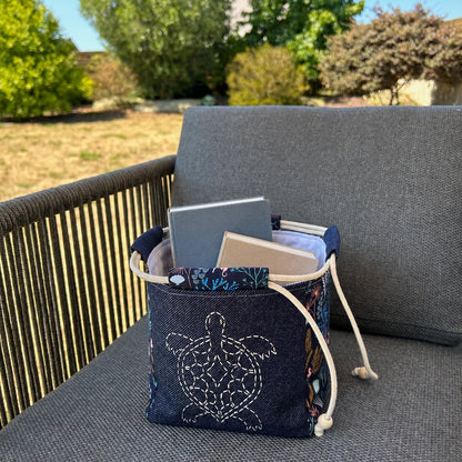 sac japonais brodé posé sur chaise et contenant des livres