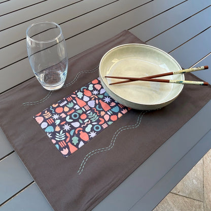 Set de table gris posé sur table avec assiette et verre