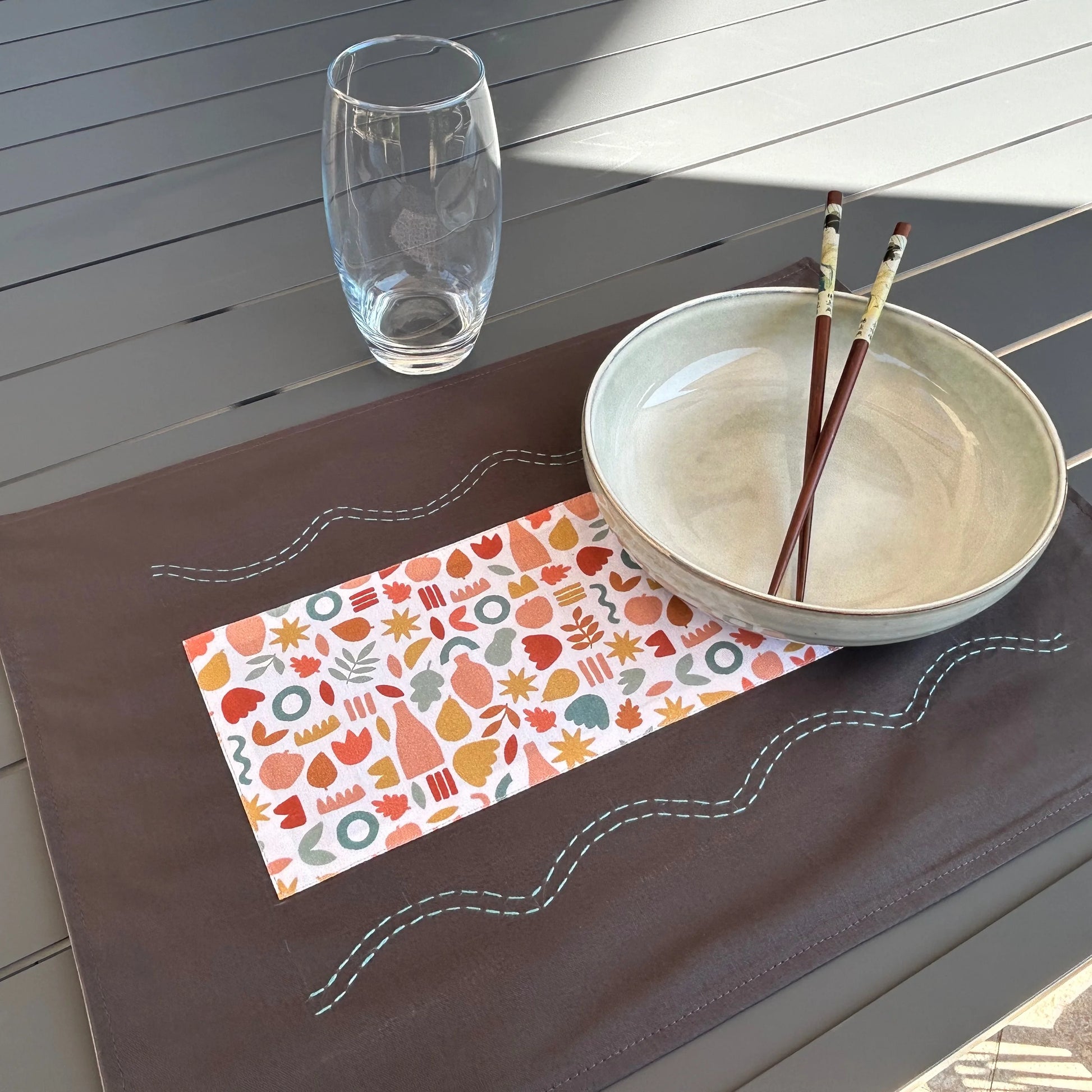 Set de table gris posé sur table avec assiette et verre