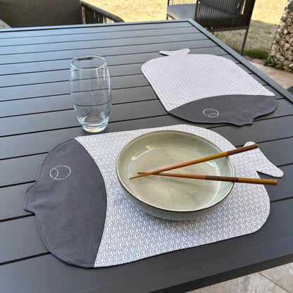 2 sets de table forme poisson gris présenté en situation avec assiette et verre