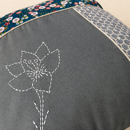 Détail de la fleur brodée au sashiko sur le coussin Fleur de Cerisier gris et bleu pétrole