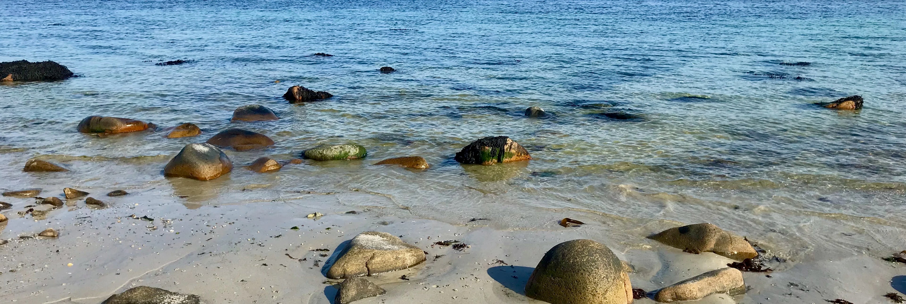 photo d'un bord de mer sable et rochers