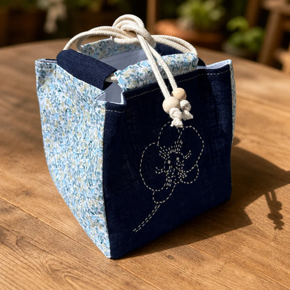 sac japonais brodé présenté fermé sur table en bois